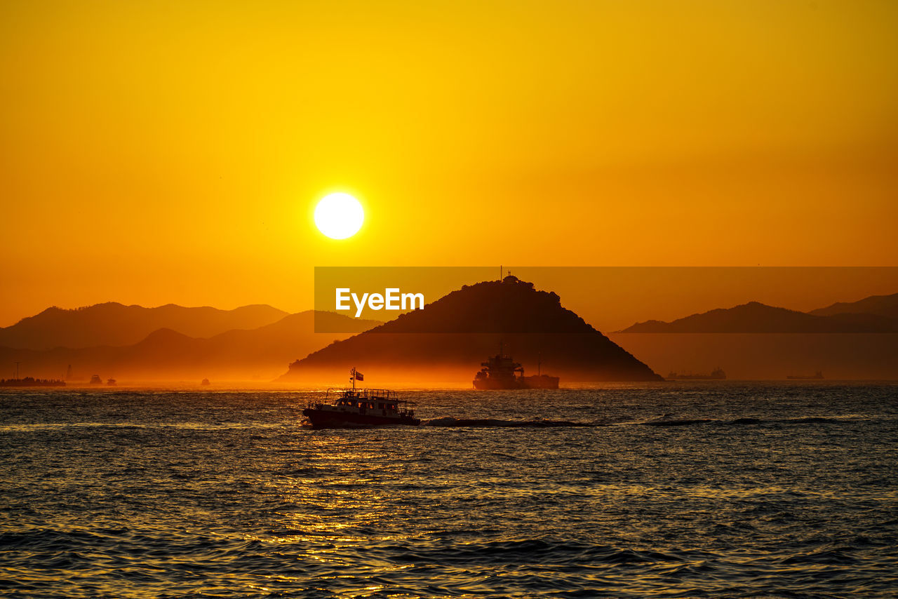 Scenic view of sea against orange sky