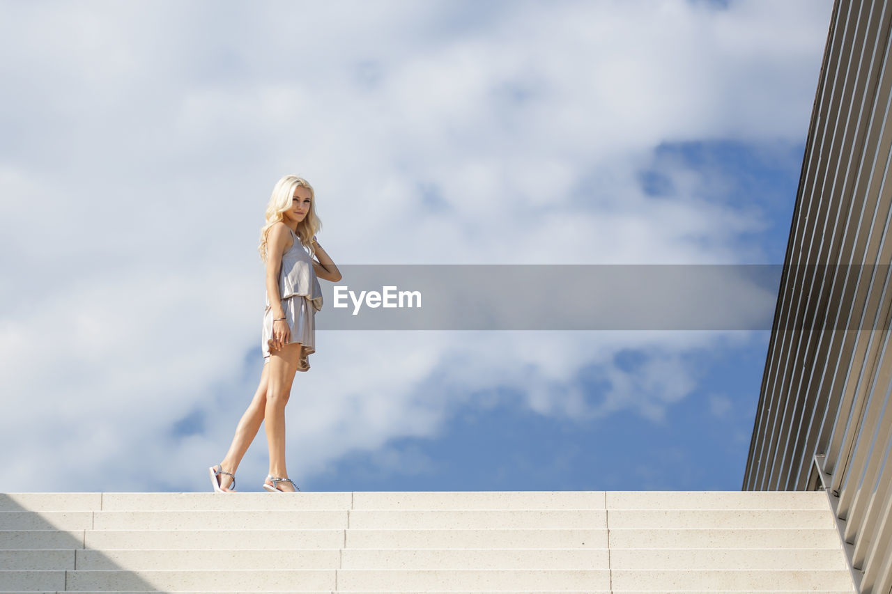 Full length of woman walking on steps against sky