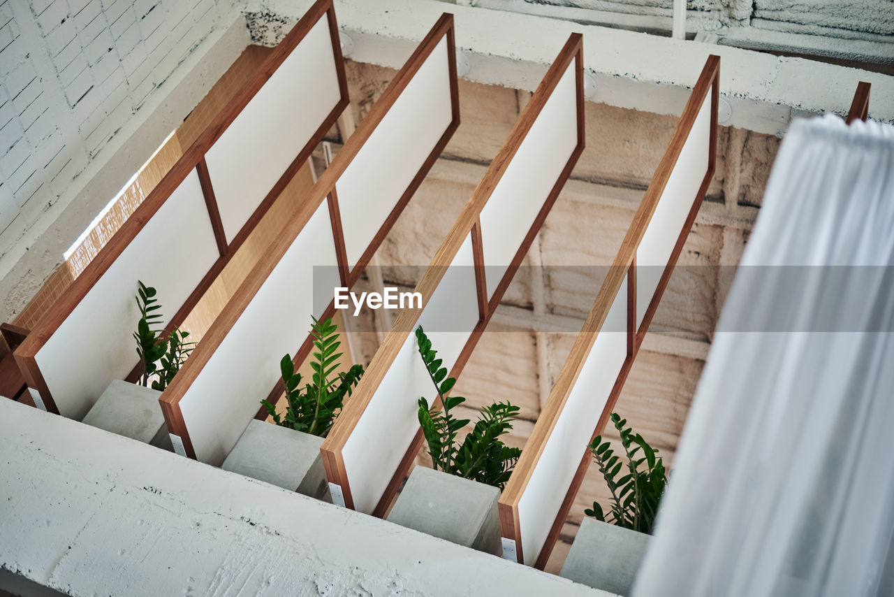 HIGH ANGLE VIEW OF CHAIRS ON TABLE AGAINST WHITE WALL