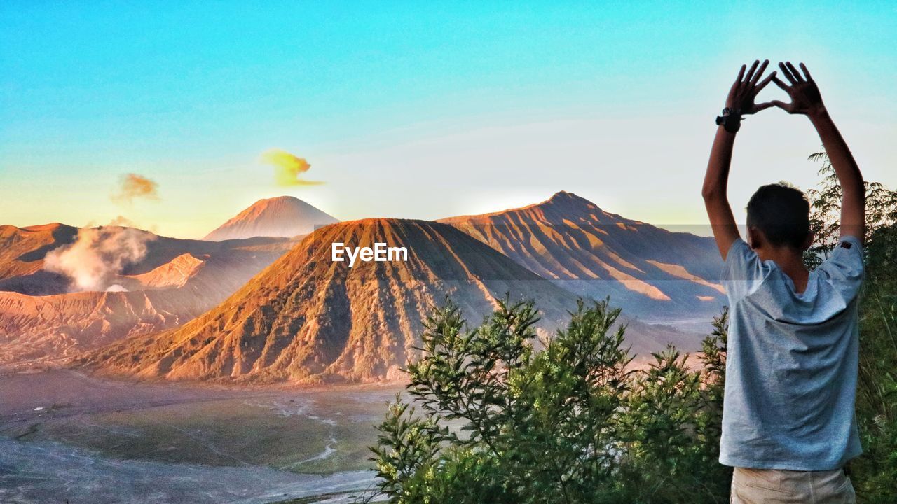 Rear view of woman standing on mountain