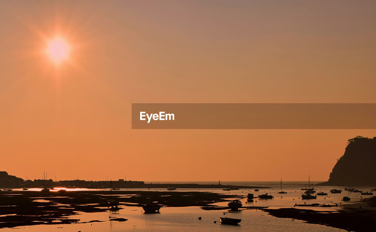 View of boats on beach during sunset 