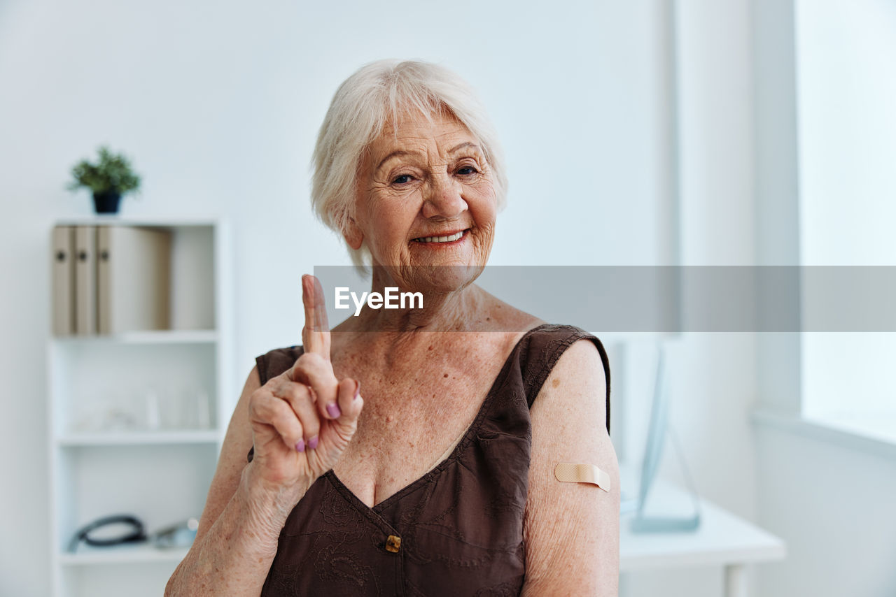 Smiling senior woman gesturing at clinic