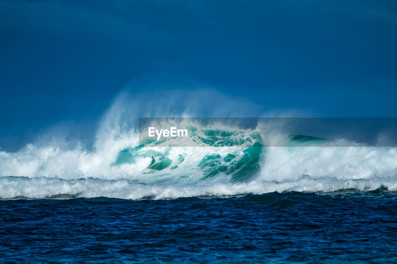 Wave in sea against blue sky