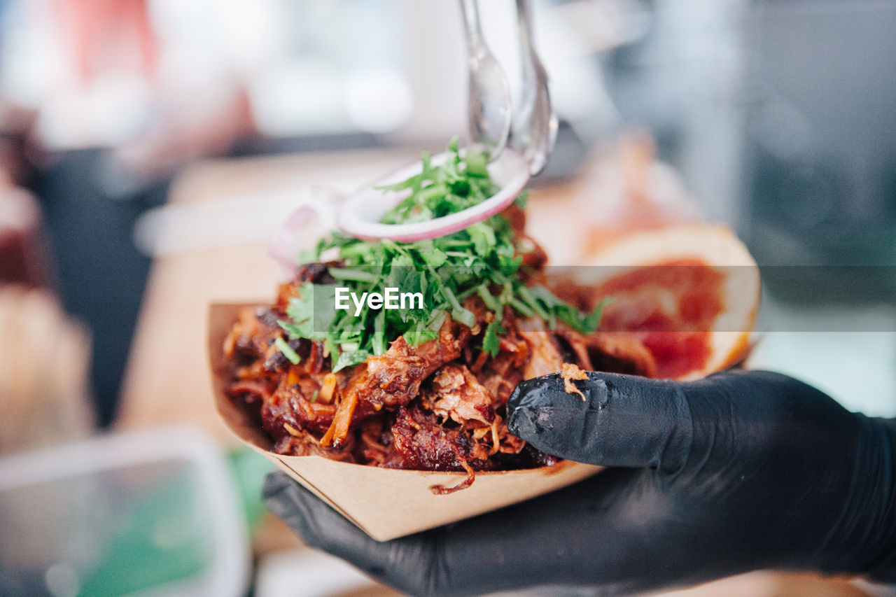 Close-up of hand serving take out food