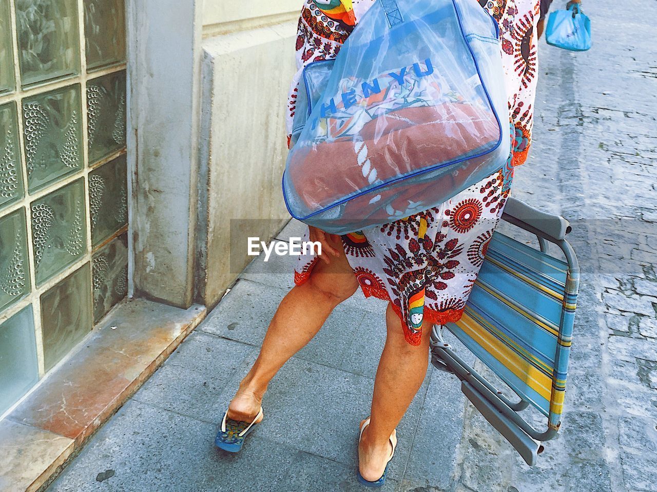 LOW SECTION OF WOMAN WITH UMBRELLA ON FLOOR