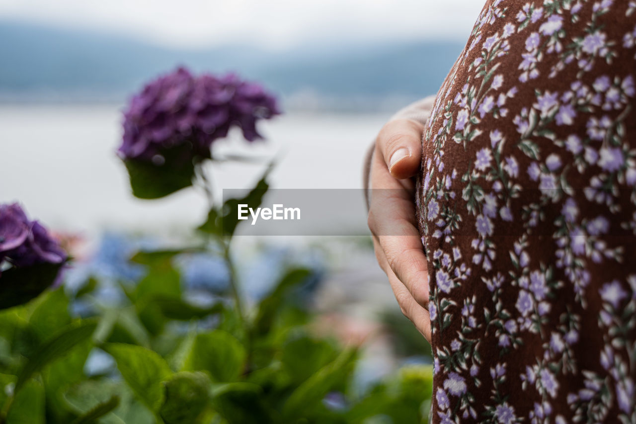Midsection of pregnant woman by flower