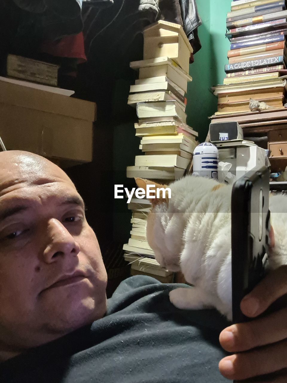 PORTRAIT OF MAN WITH CAT ON BOOKS