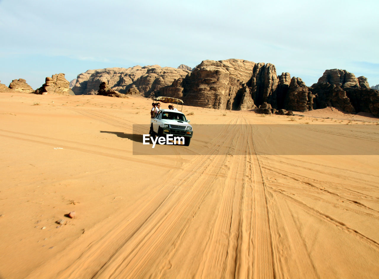 CARS ON ROAD AGAINST DESERT