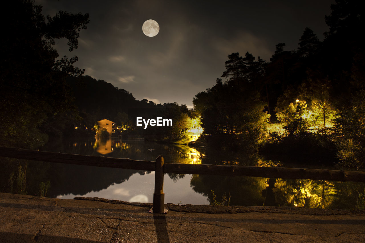 Scenic view of lake against sky at night