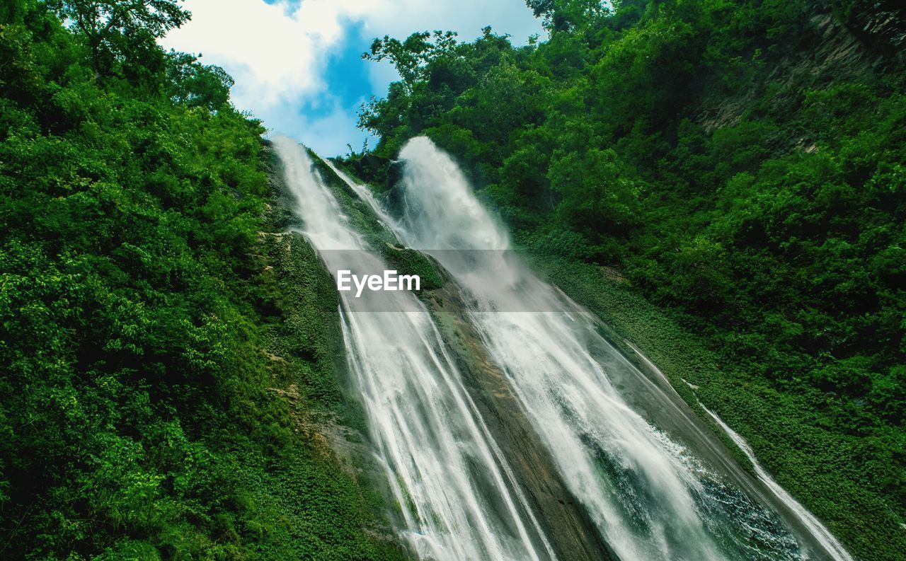 Scenic view of waterfall against sky