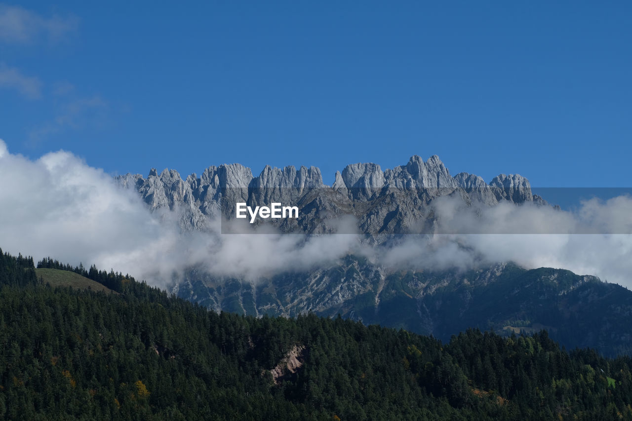 Kaisermountain breathtaking scenery with blue sky, liw hanging white clouds 
alpine peaks and valley