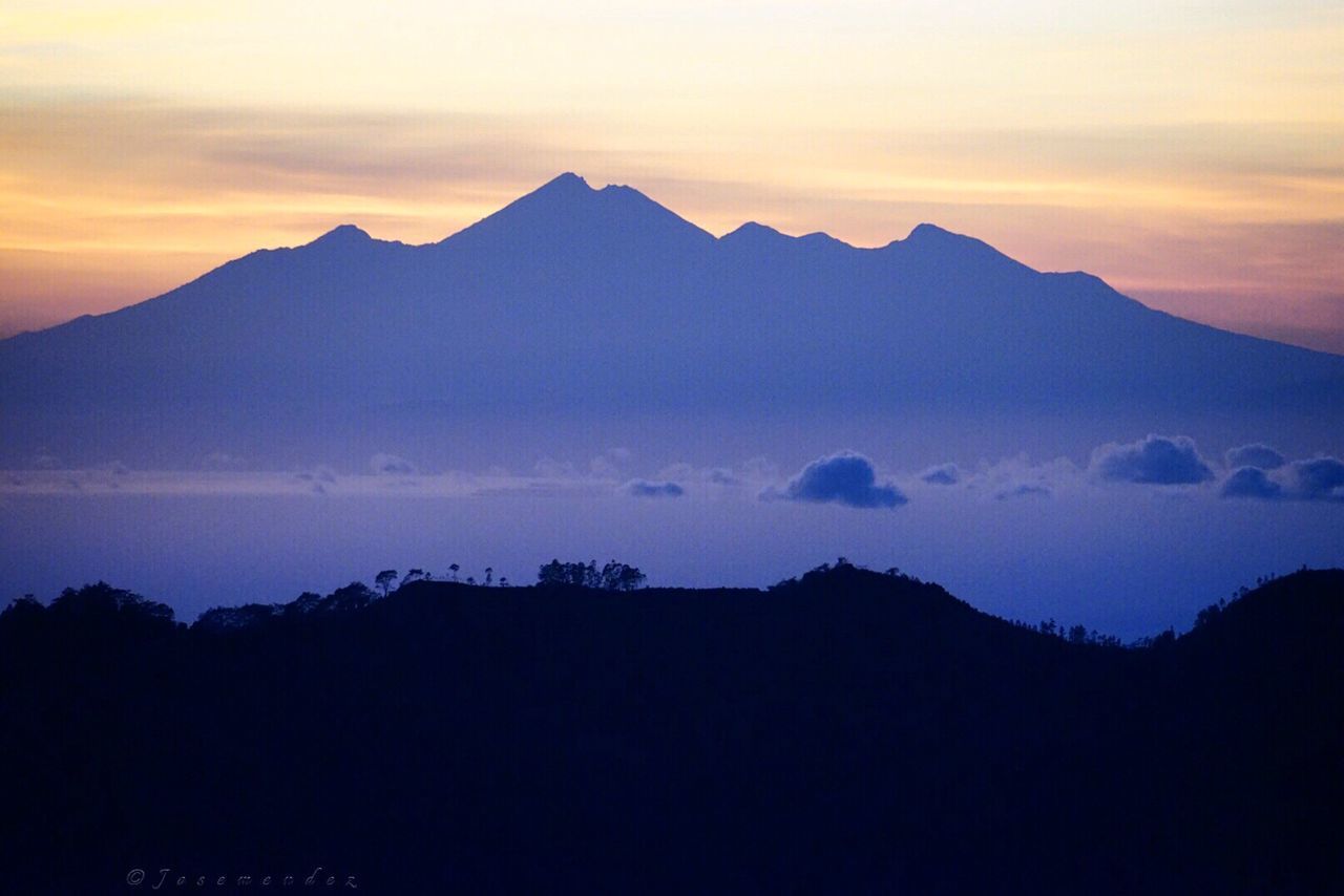 Scenic view of silhouette mountains against sky at sunset