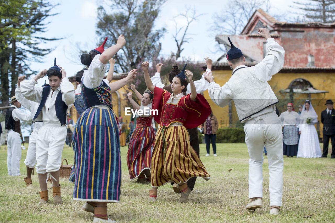 GROUP OF PEOPLE ON FIELD BY TREES