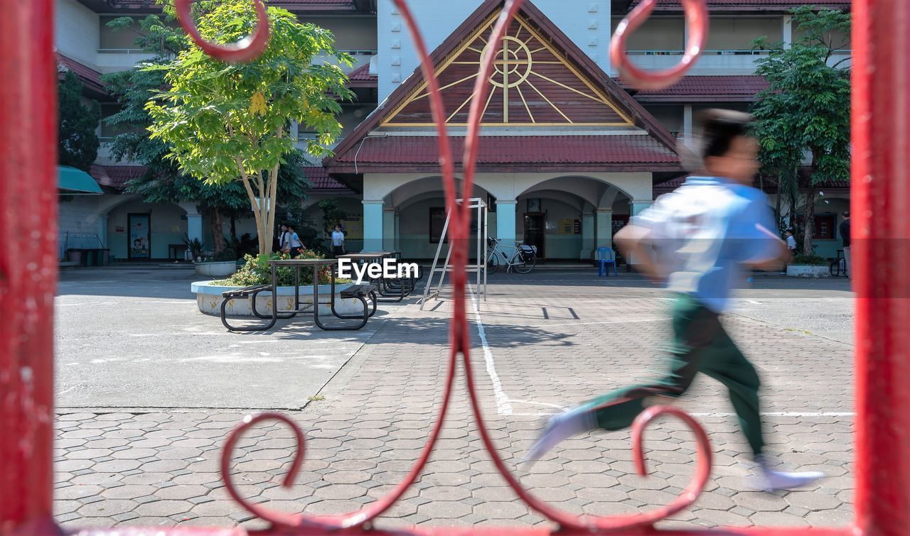 MAN RIDING BICYCLE ON STREET AGAINST BUILDING