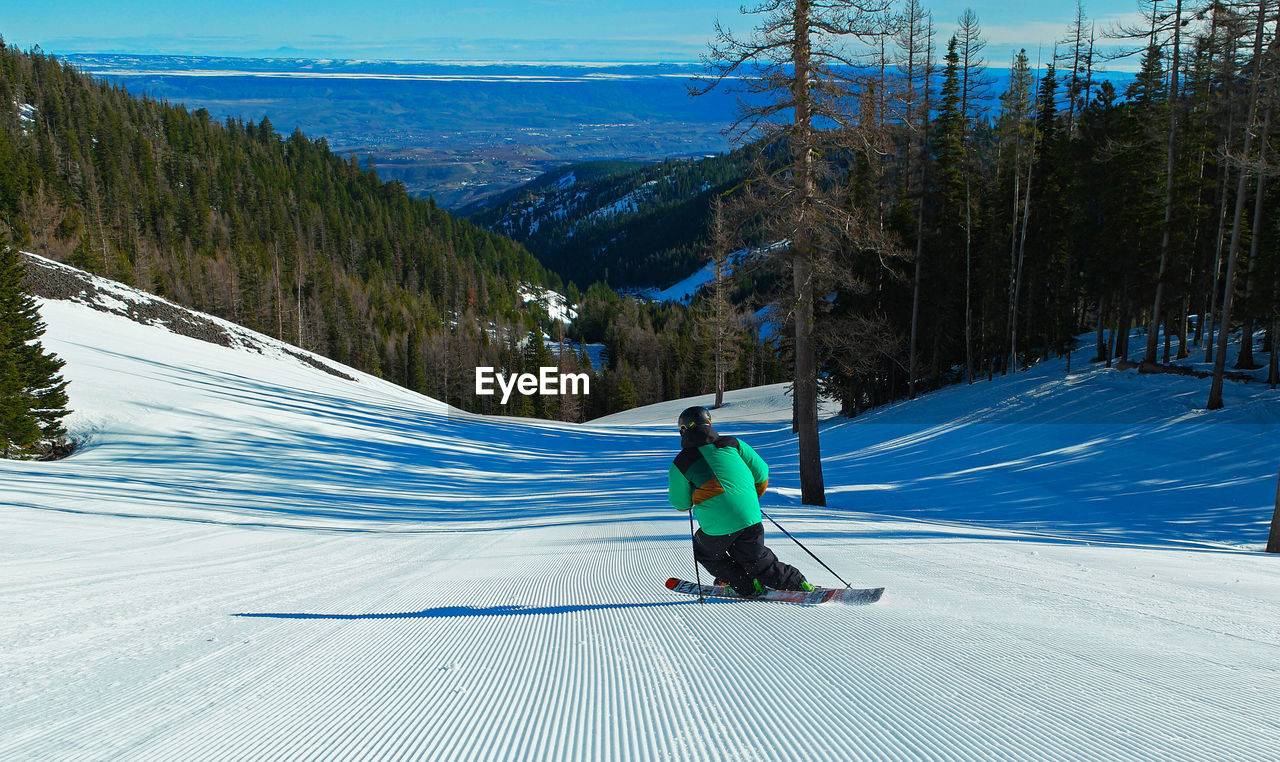 Rear view of woman skiing on snow landscape