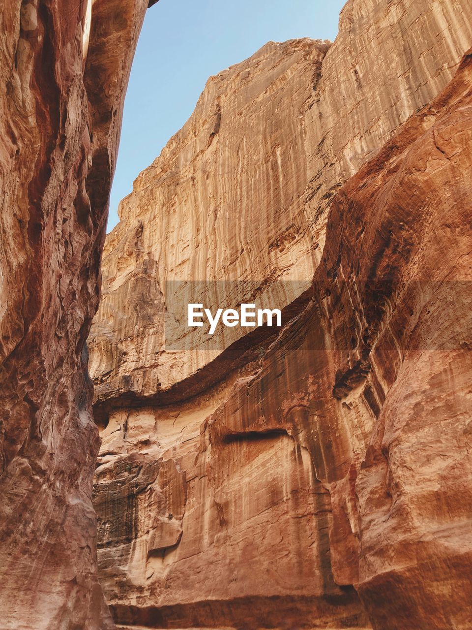 Looking to the sky trough rock formations in the siq, entrance path to petra heritage site, jordan
