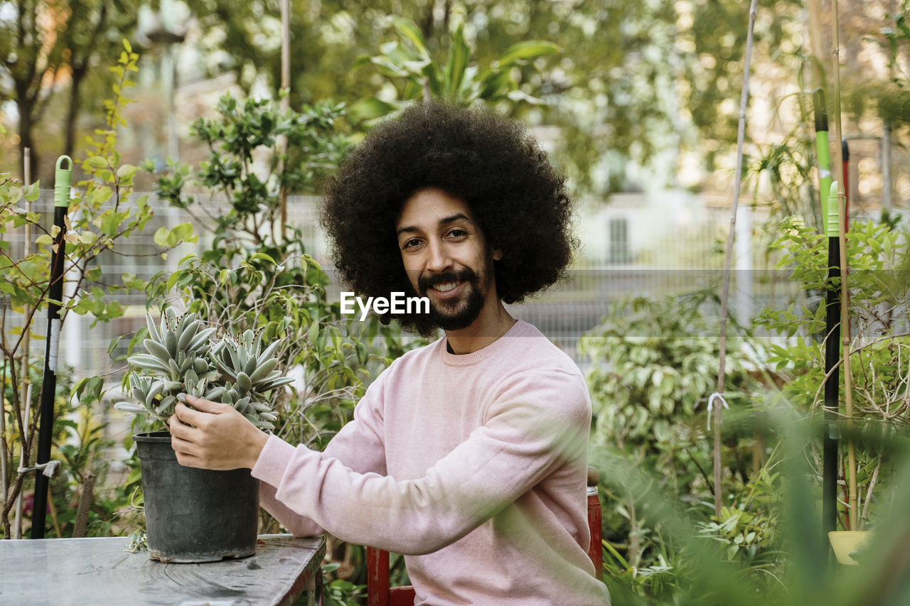 Mid adult man with pot in garden