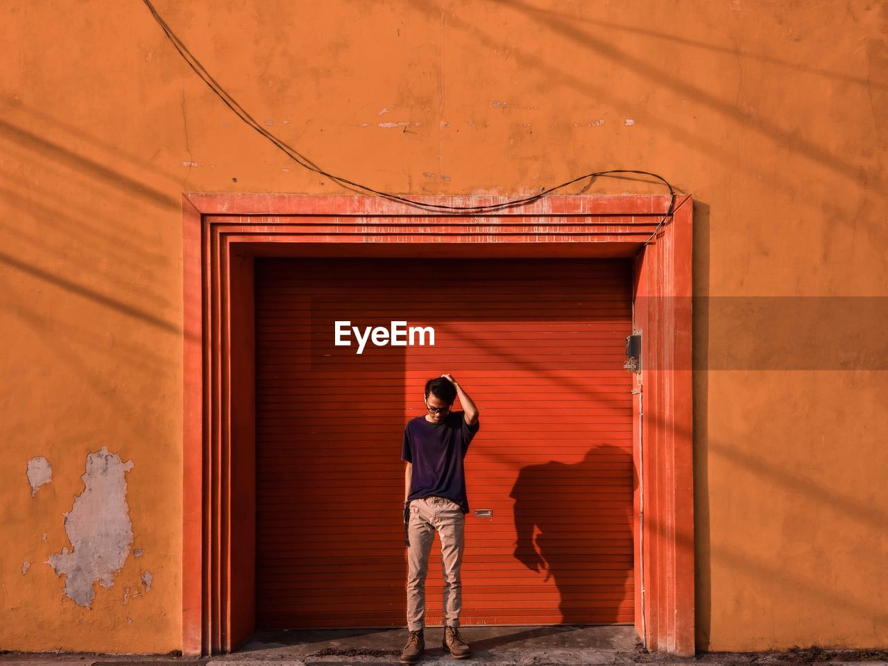 Man standing against entrance of building