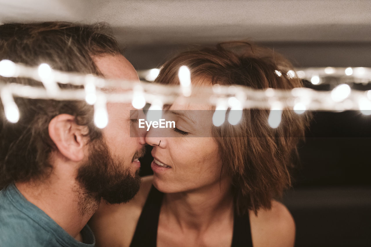 Affectionate couple romancing in van at night