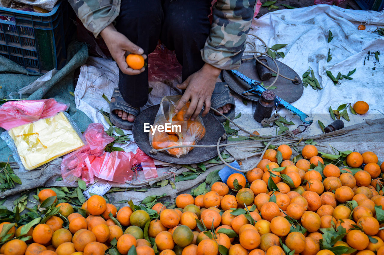 High angle view of man selling mandarine oranges in the street market
