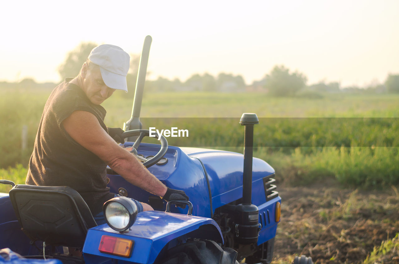 A farmer on a tractor drives across the farm field. agricultural management skills and earthworks