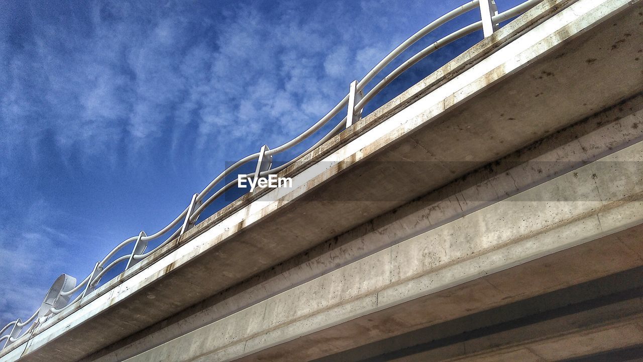 LOW ANGLE VIEW OF BRIDGE OVER RAILING AGAINST SKY