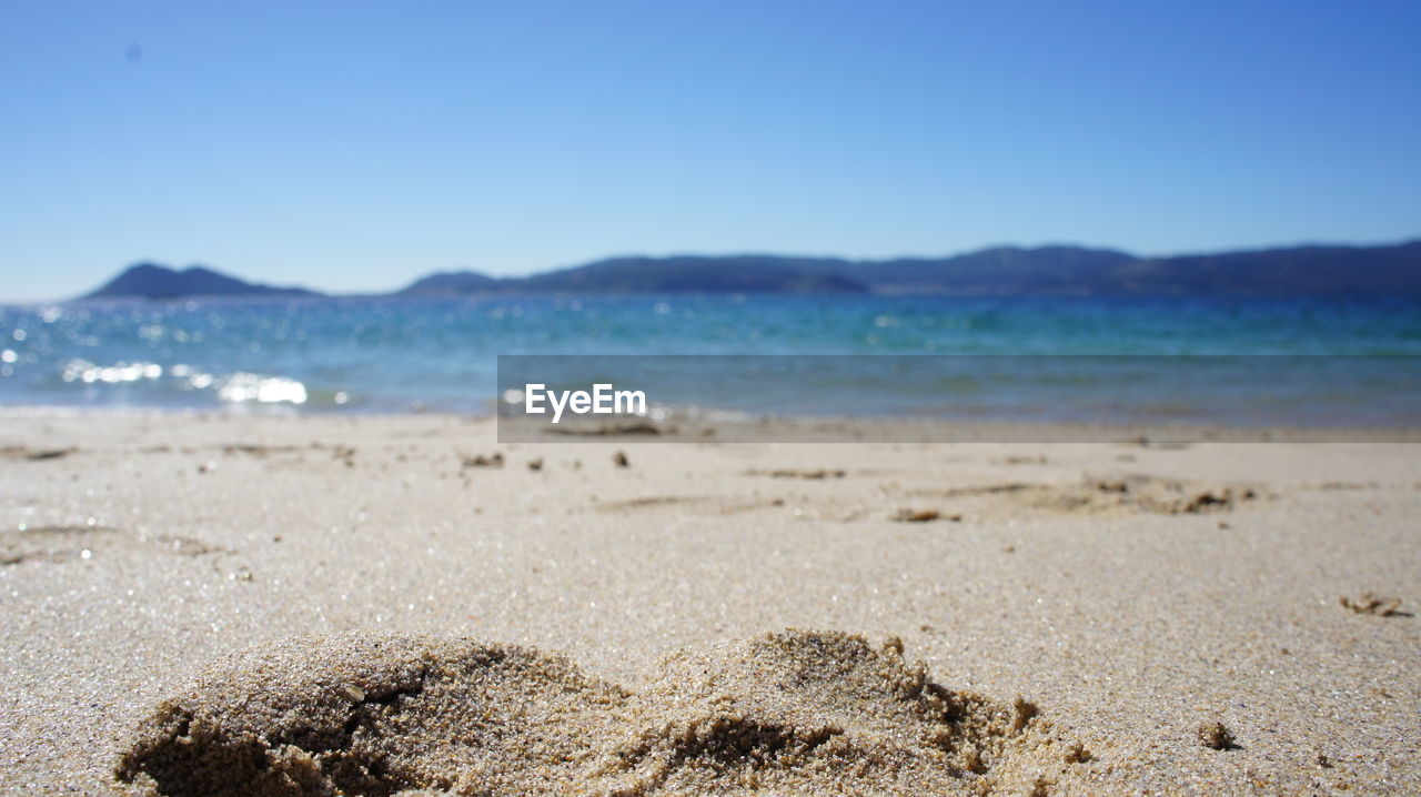 Scenic view of beach against blue sky