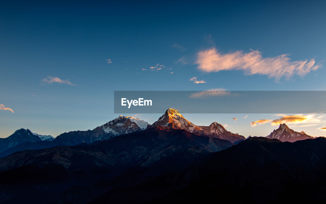 Scenic view of snowcapped mountains against sky during sunset