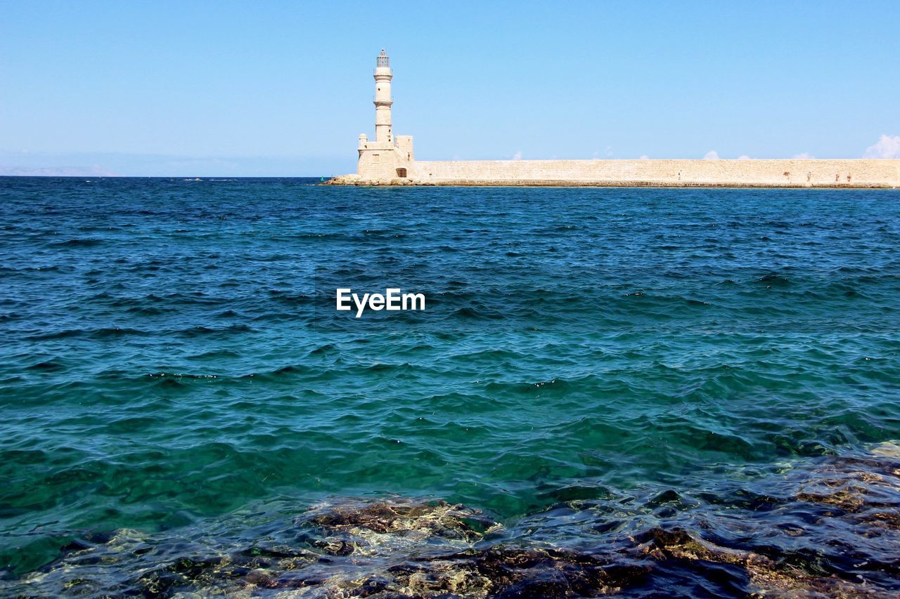 Distance shot of lighthouse against calm sea