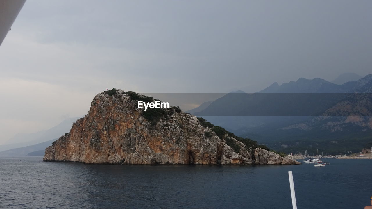 Scenic view of sea and mountains against sky