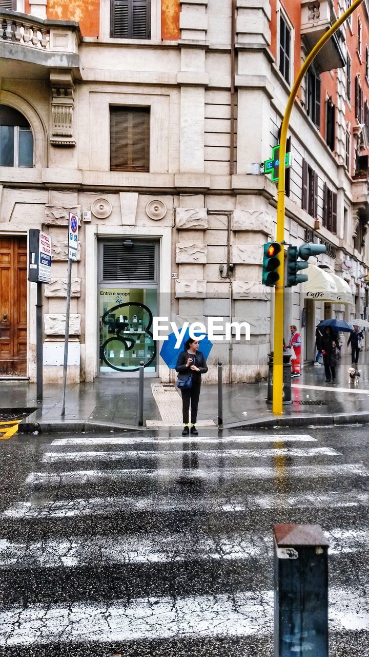 MAN WALKING WITH UMBRELLA ON WET STREET