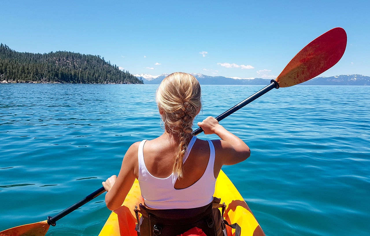 Rear view of woman boating on sea