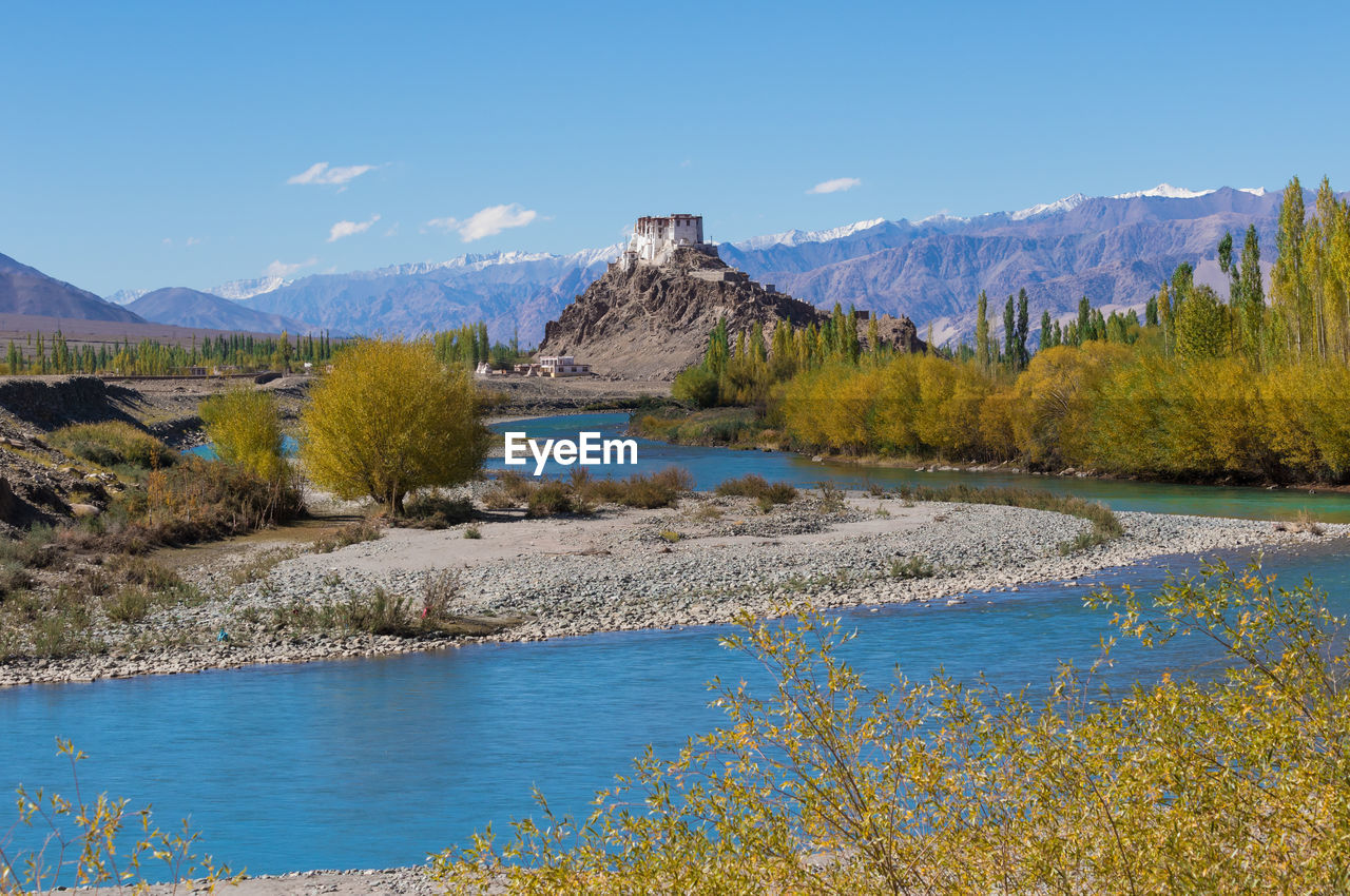 Scenic view of river and landscape against blue sky