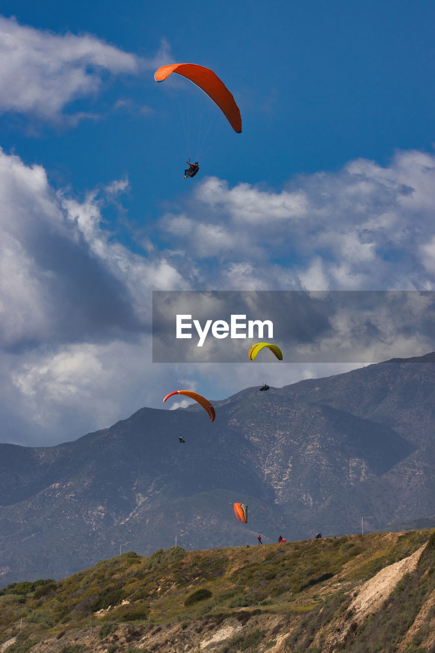 low angle view of person paragliding against mountain