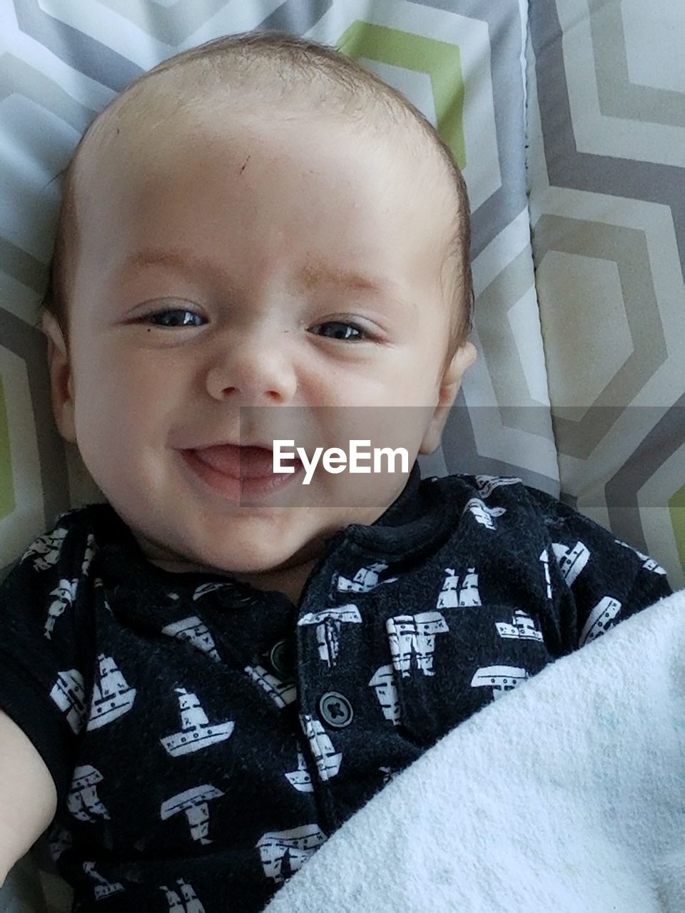 Directly above portrait of cute baby boy lying on bed at home