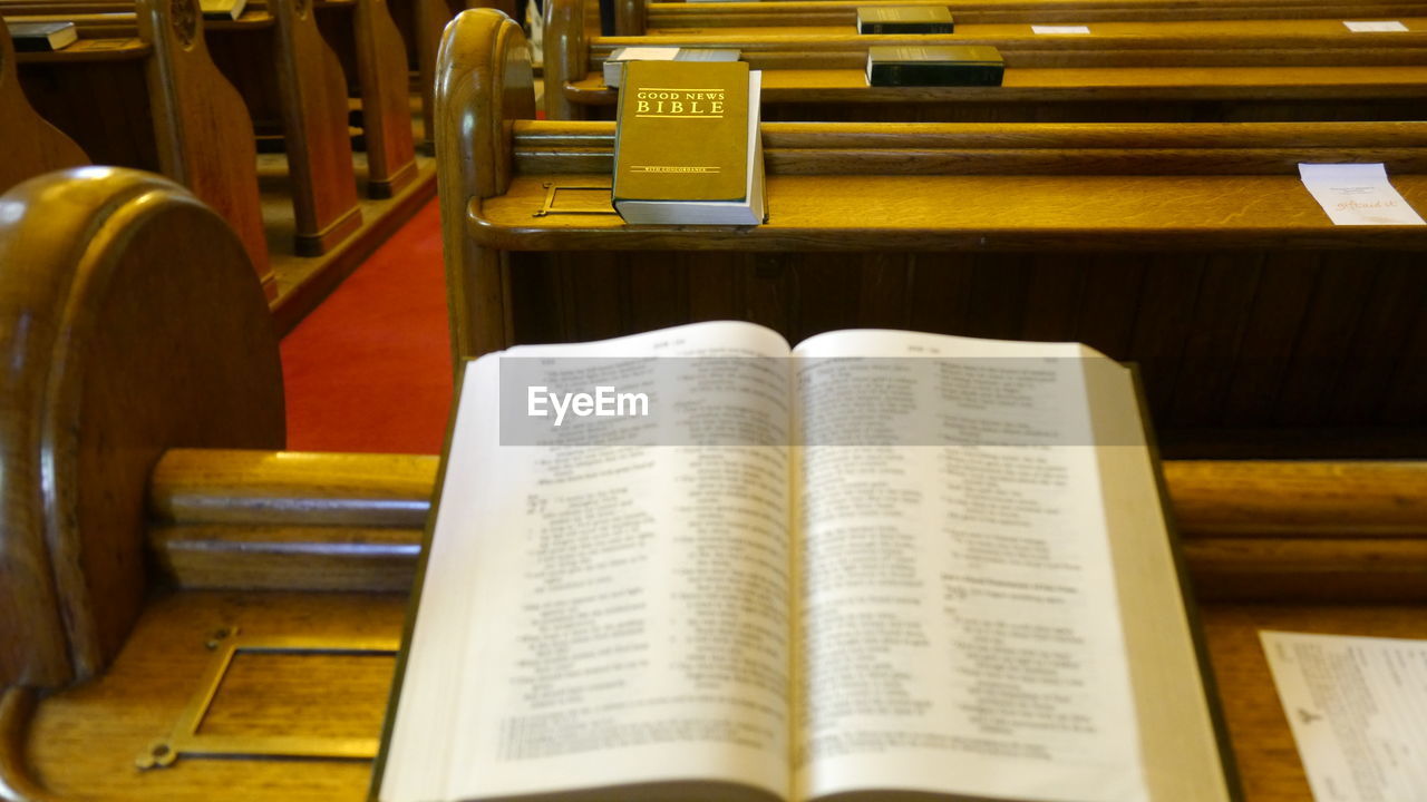 High angle view to holy bible on pew in church 