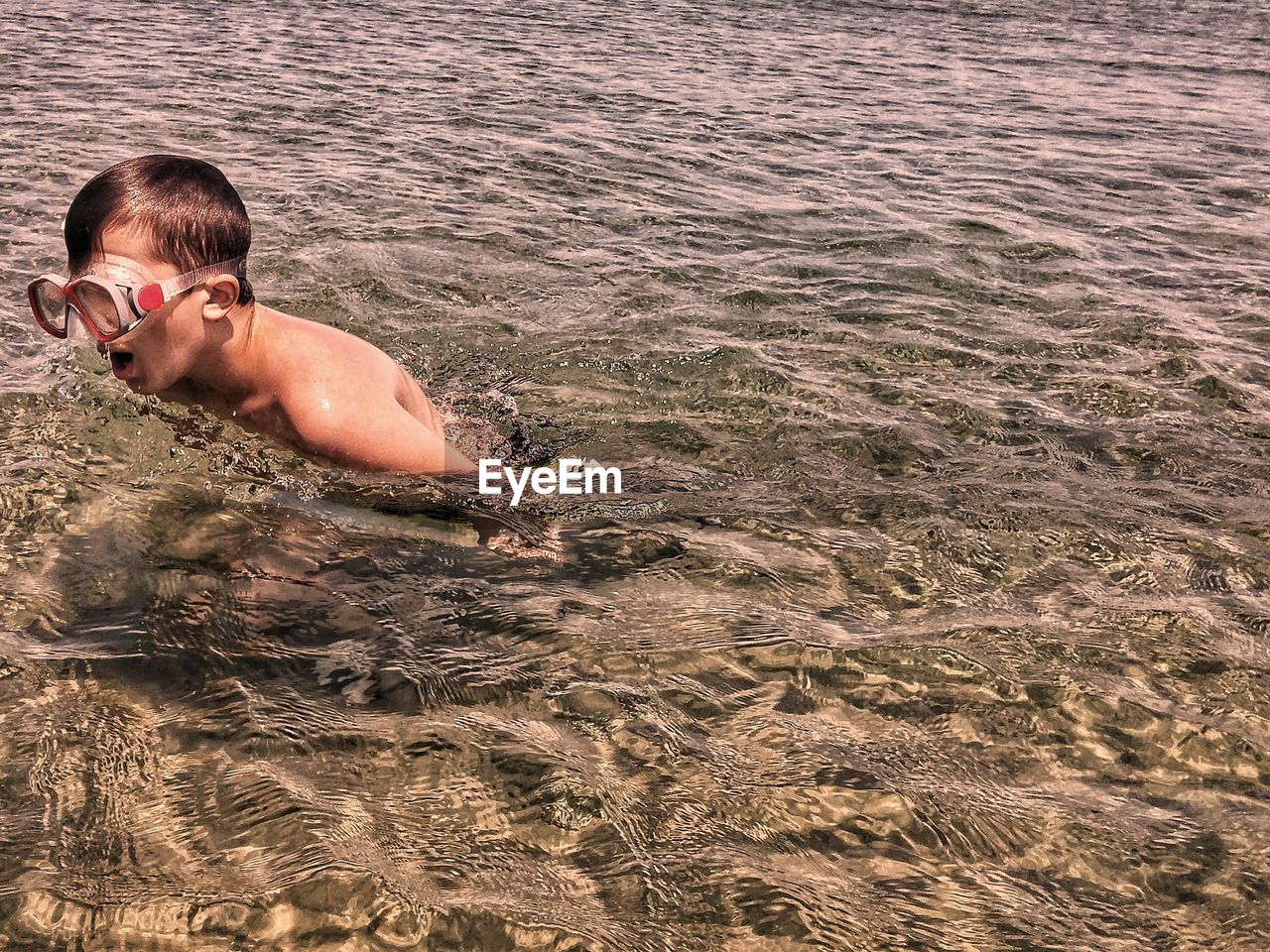 High angle view of shirtless boy swimming in sea
