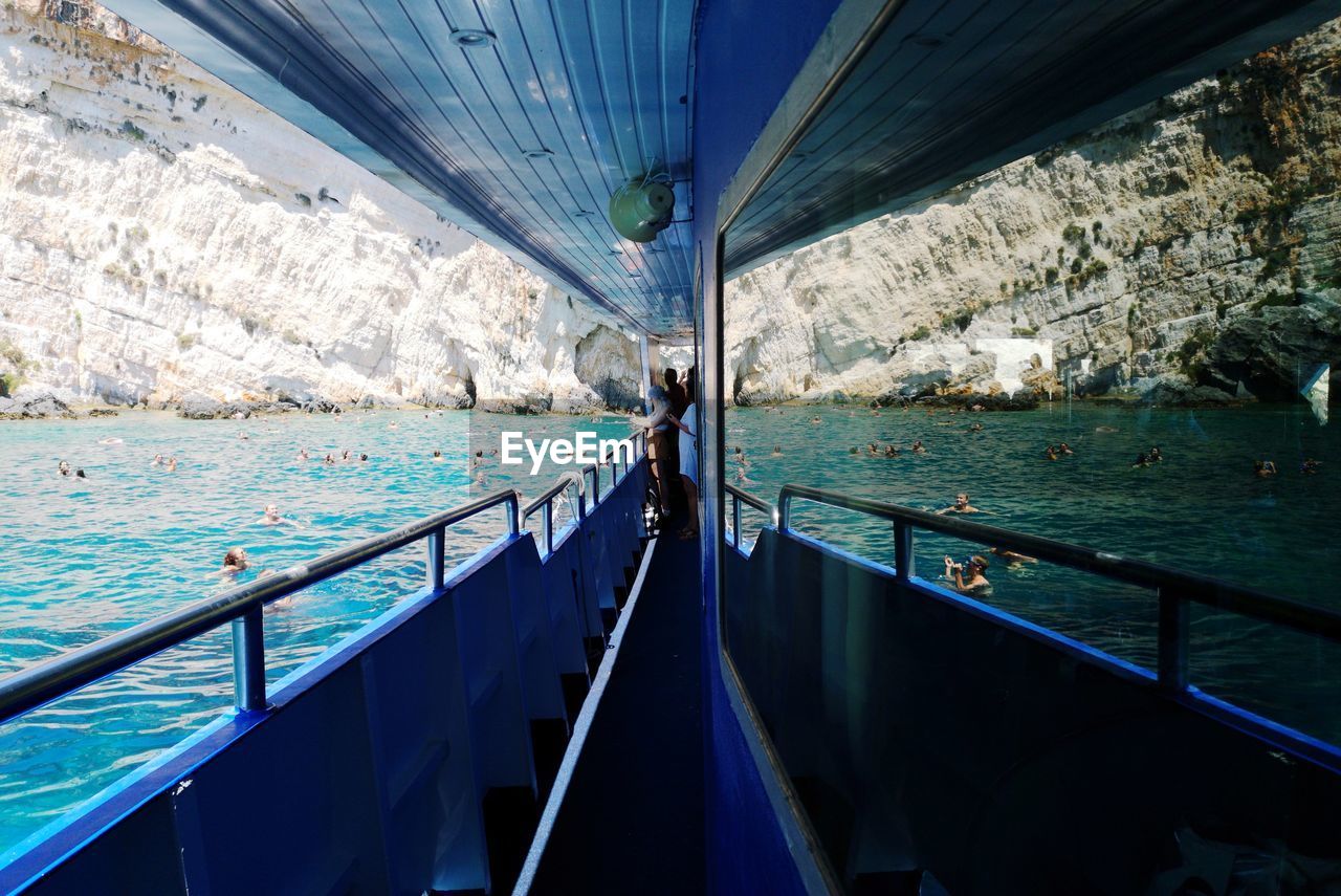 People reflecting in boat on sea