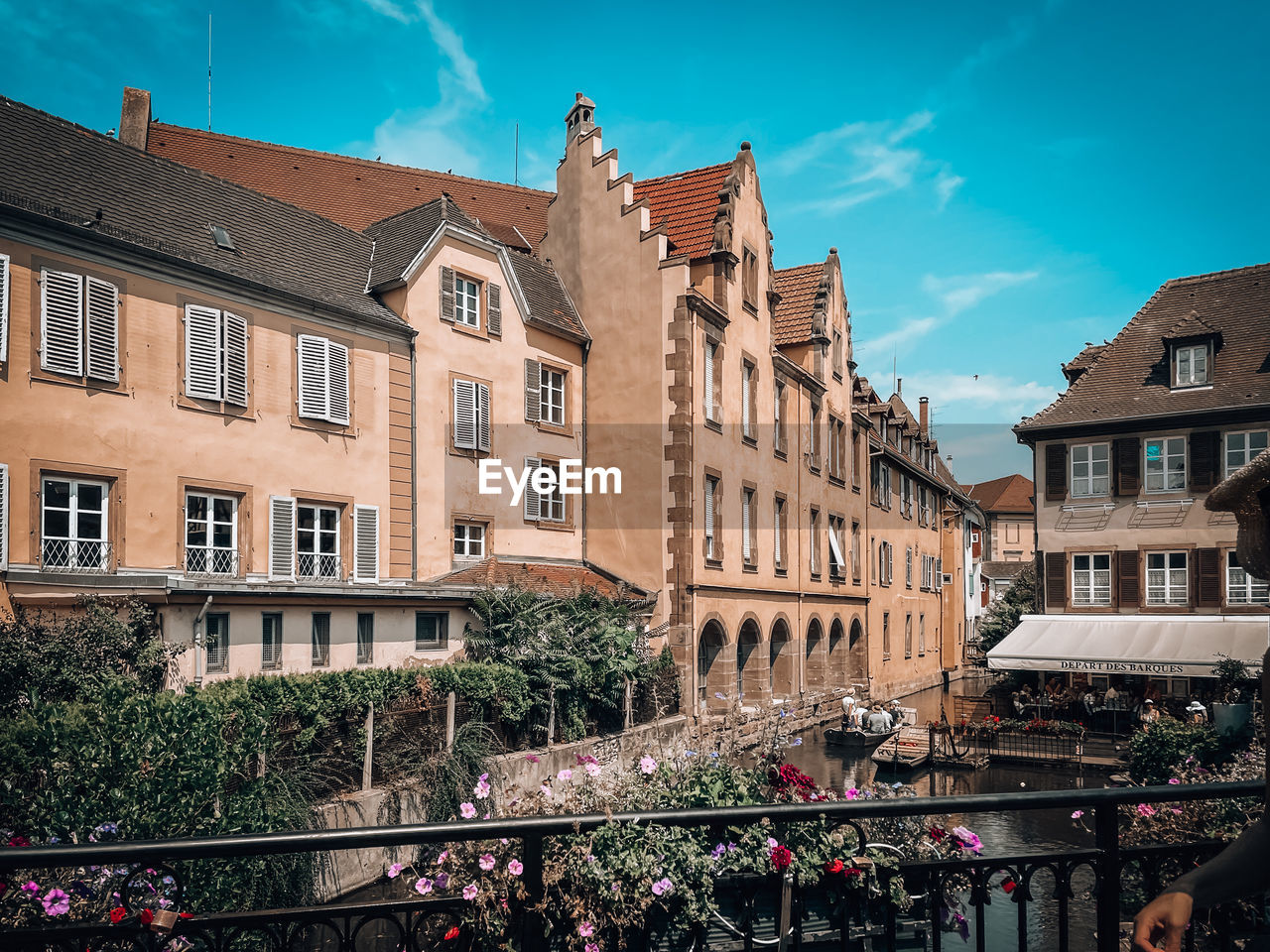 architecture, building exterior, built structure, city, cityscape, town, building, sky, urban area, nature, travel destinations, downtown, street, waterway, window, residential district, tourism, travel, neighbourhood, landmark, history, the past, town square, outdoors, plant, city life, house, city street, crowd, cloud, group of people, day, blue, old, water, facade