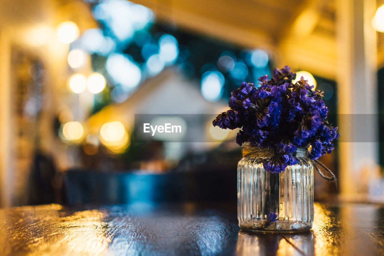 Close-up of purple flowers in mason jar at table