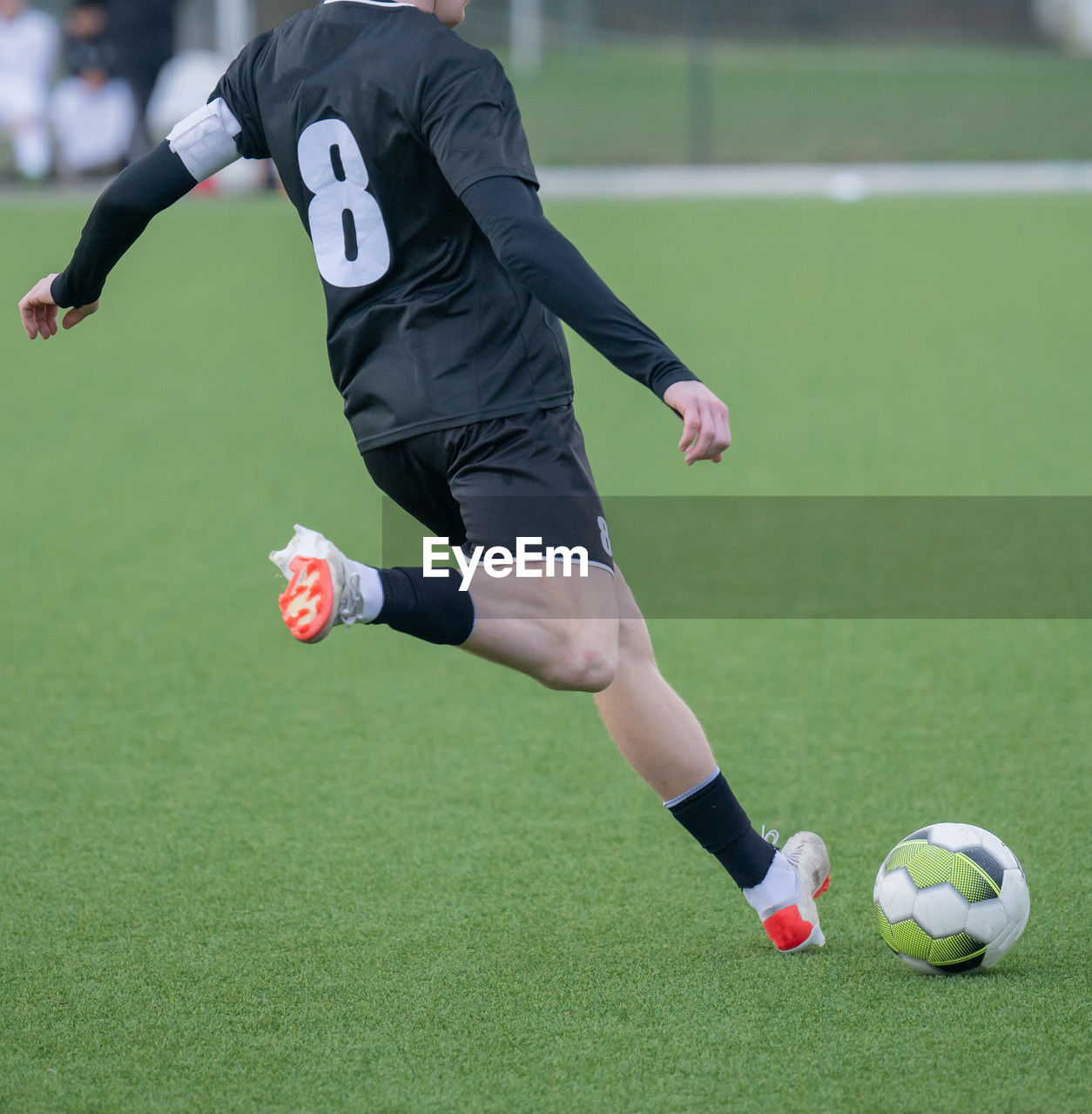 low section of man playing soccer on field