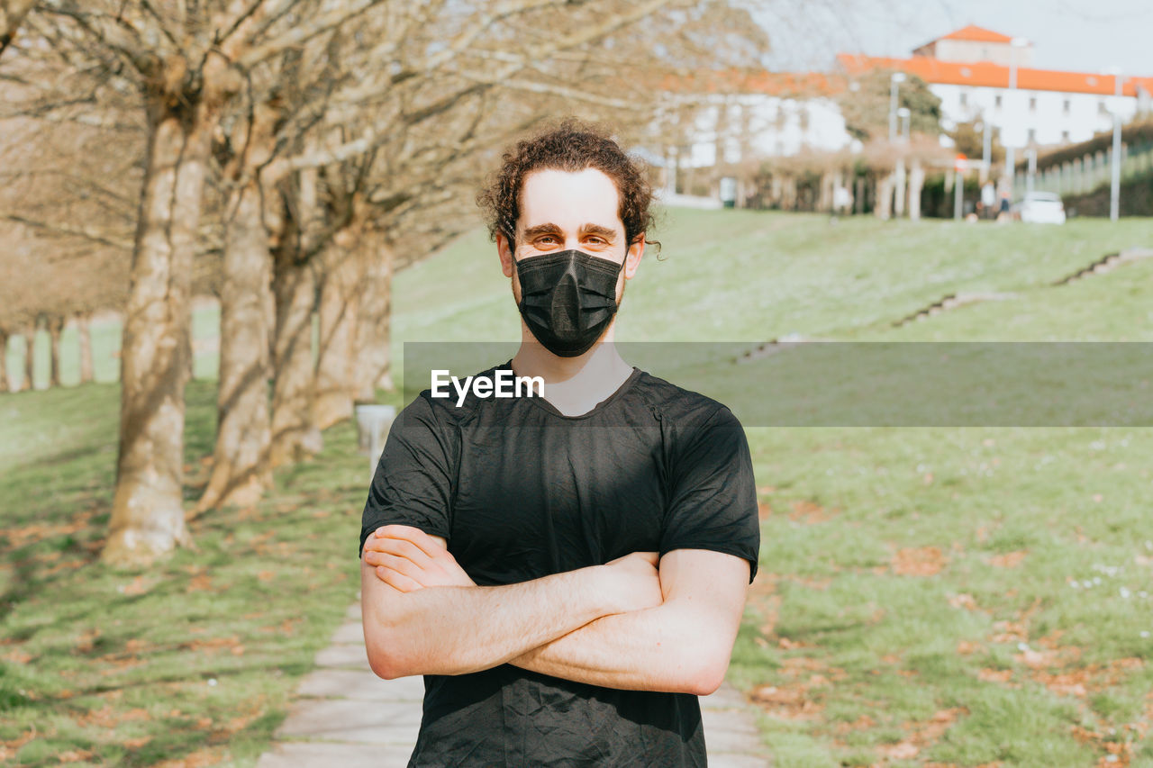 Portrait of young man wearing mask standing outdoors