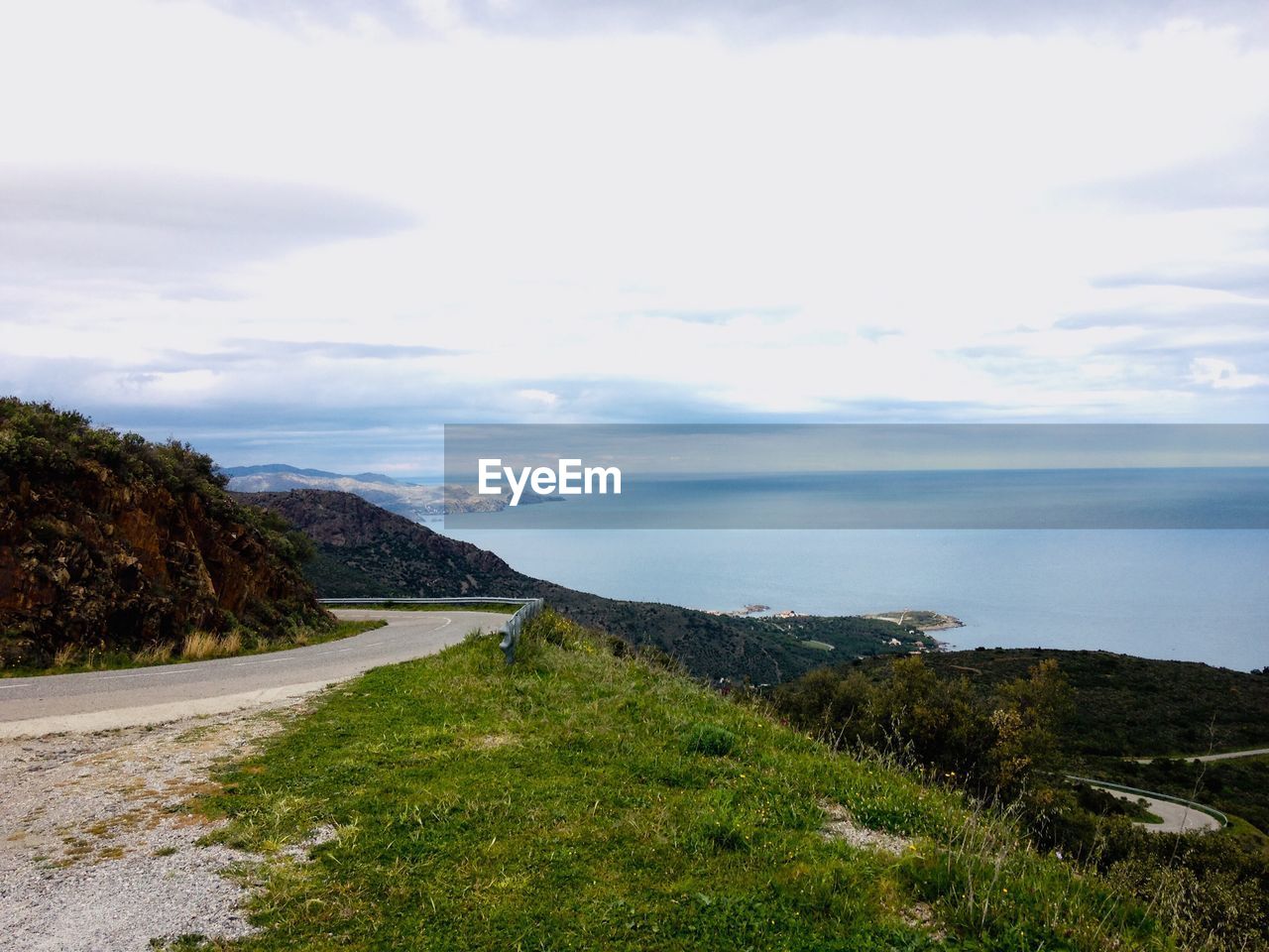 SCENIC VIEW OF ROAD AMIDST SEA AGAINST SKY