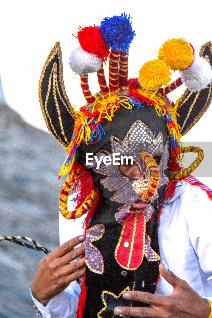 PORTRAIT OF MAN WEARING MULTI COLORED TRADITIONAL CLOTHING