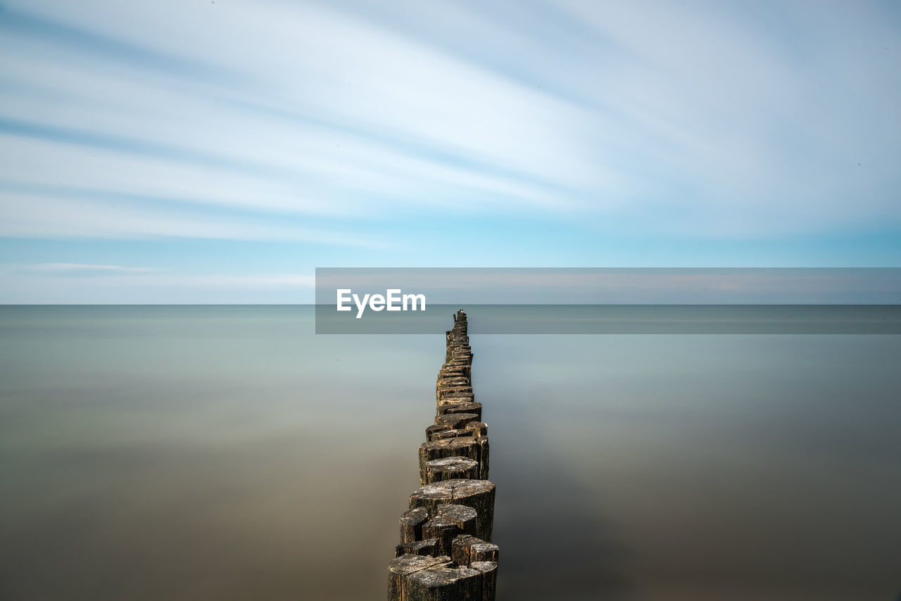 Groyne in sea against sky