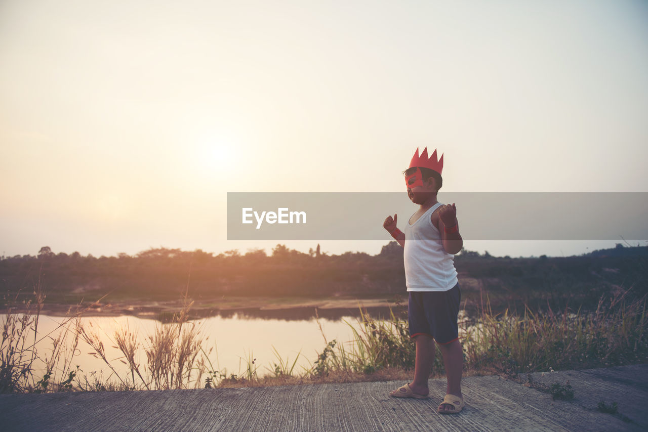 Boy with cape and eye patch playing in park