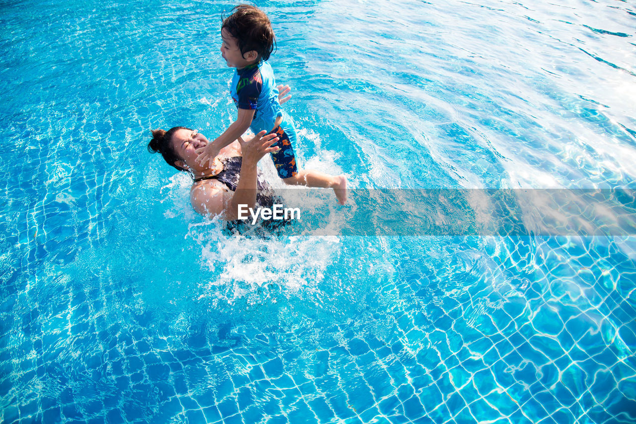Cheerful mother and son in swimming pool