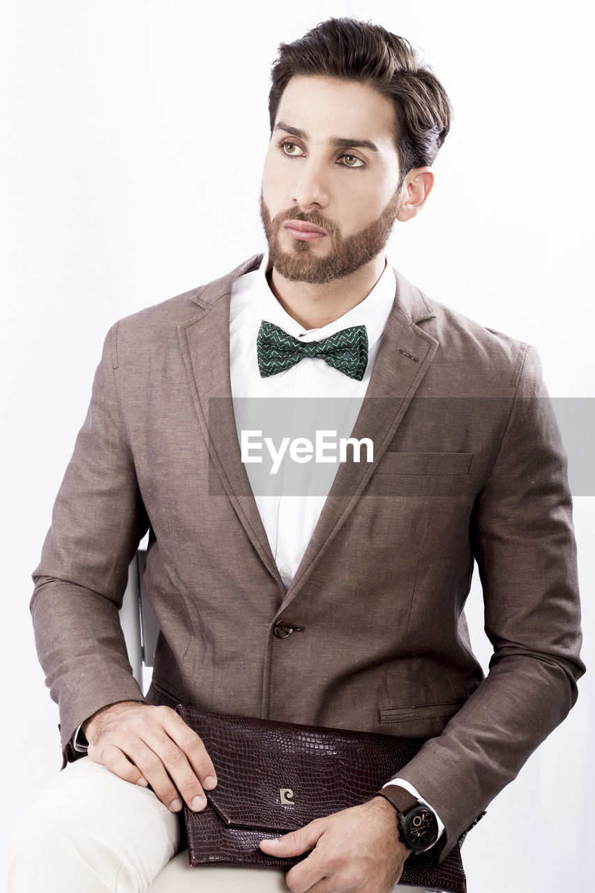 Handsome young man standing against white background