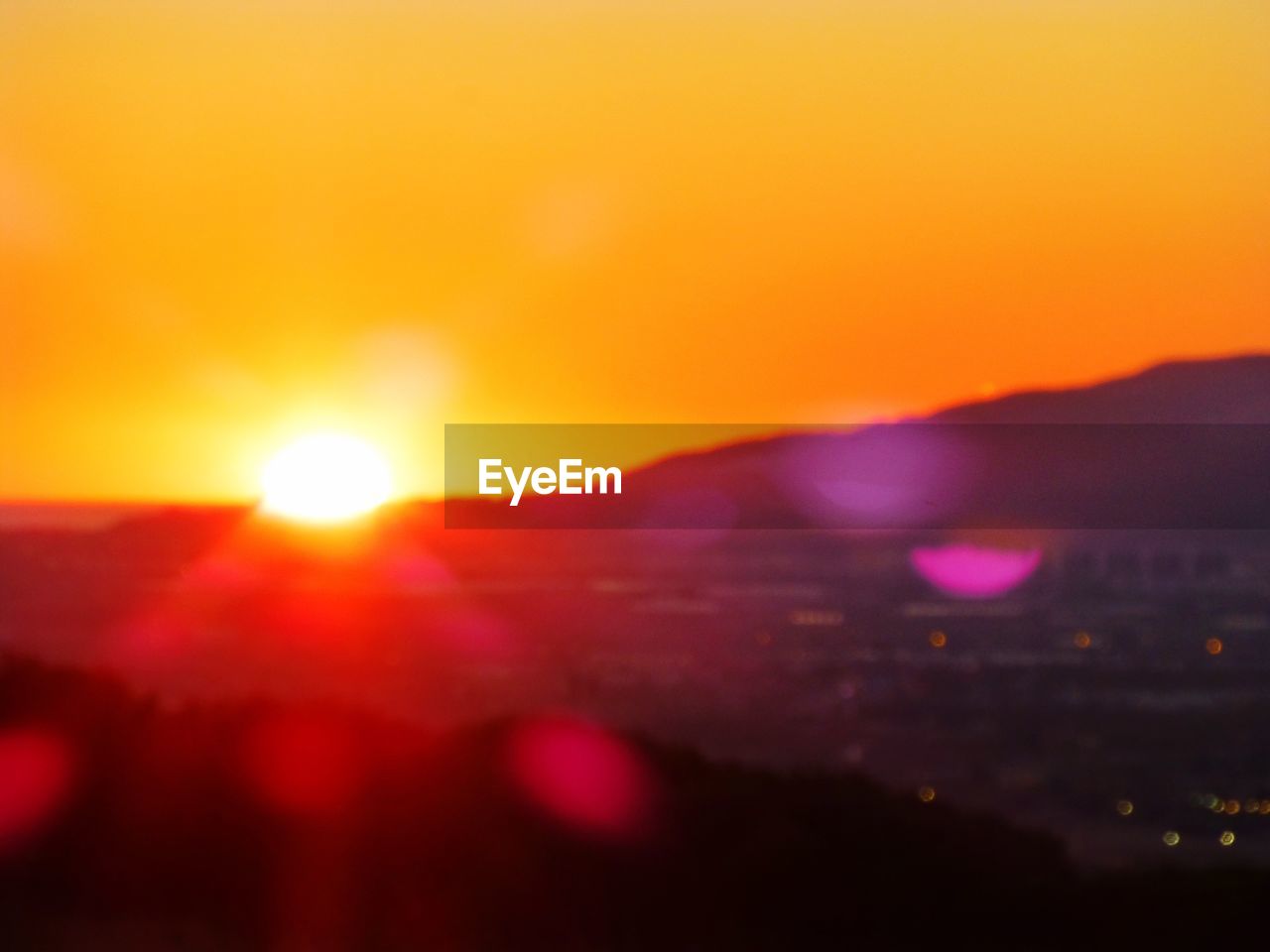 CLOSE-UP OF ORANGE SKY OVER MOUNTAINS