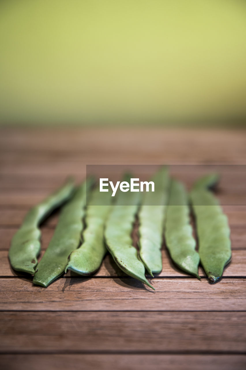 CLOSE-UP OF GREEN CHILI PEPPER ON TABLE